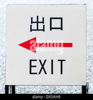 Schild mit einem roten Pfeil nach links und das Wort EXIT in englischer Sprache und in japanischen Kanji-Schrift die Symbole für beenden und Mund Stockfoto