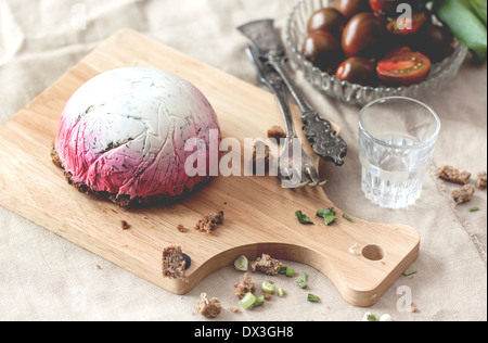 Leckerer Snack Salat Hering unter einem Pelzmantel auf Holzbrett mit Gabel und russischen Wodka Stockfoto