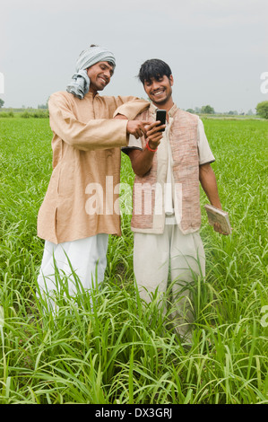 Indische Bauern stehen mit Mobile Stockfoto