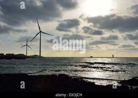 Elektro Power Generator Windkraftanlage über ein bewölkter Himmel in Jeju Küste Stockfoto