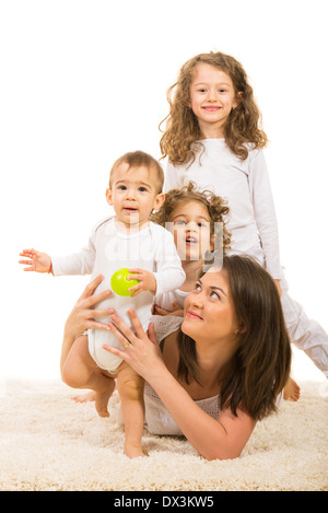 Fröhliche Familie, Mutter und drei Kinder auf Teppich zu Hause liegen Stockfoto