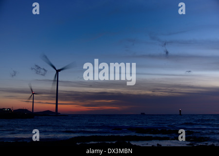 Elektro Power Generator Windkraftanlage über ein bewölkter Himmel in Jeju Küste Stockfoto