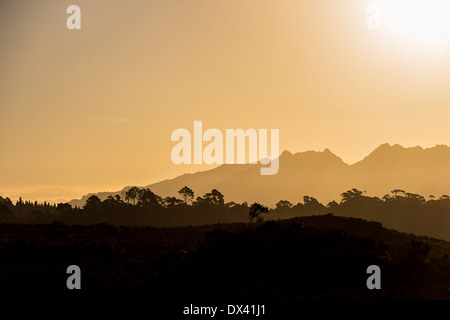 Die untergehende Sonne über einer Bergkette am späten Nachmittag Stockfoto