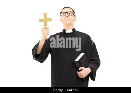 Priester ein Kreuz haltend und nachschlagen Stockfoto
