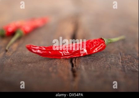 trockene rote Chilischoten über alten Holztisch Stockfoto