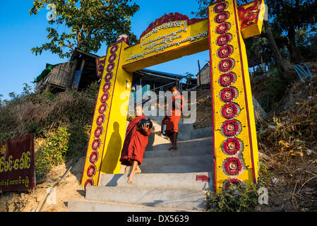 Buddhistischen Novizen mit Betteln Schalen bei ihren morgendlichen betteln Tour, Tor und Treppe zum Kloster, Mount Popa, in Bagan Stockfoto