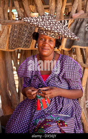 Herero-Frau mit typischen Kopfschmuck Nähen Souvenirs, Namibia Stockfoto