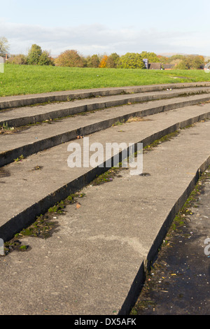 Flache terrassenförmig angelegten Stufen für die Zuschauer durch die stillgelegten Laufstrecke am Harper grün Spielfelder, Farnworth, Lancashire. Stockfoto