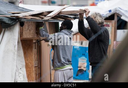Berlin, Deutschland. 18. März 2014. Berlin, Deutschland. 18. März 2014. Zwei Männer arbeiten an einer Woeden Hütte im Flüchtlingslager am Oranienplatz-Platz in Berlin, Deutschland, 18. März 2014. Die angefochtenen Flüchtlingslager wird jetzt wahrscheinlich freiwillig demontiert werden. Foto: Paul Zinken/Dpa/Alamy Live News Stockfoto