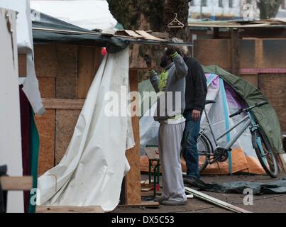 Berlin, Deutschland. 18. März 2014. Berlin, Deutschland. 18. März 2014. Zwei Männer arbeiten an einer Woeden Hütte im Flüchtlingslager am Oranienplatz-Platz in Berlin, Deutschland, 18. März 2014. Die angefochtenen Flüchtlingslager wird jetzt wahrscheinlich freiwillig demontiert werden. Foto: Paul Zinken/Dpa/Alamy Live News Stockfoto