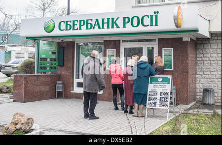 Simferopol, Ukraine. 18. März 2014. Menschen stehen vor der russischen Sberbank um Geld in Simferopol, Ukraine, 18. März 2014 zu ziehen. Putin hält an seinem Kurs trotz Sanktionen von westlichen Nationen. Foto: HANNIBAL/Dpa/Alamy Live News Stockfoto