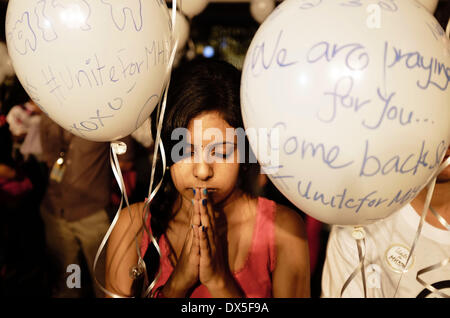 Petaling Jaya, SELANGOR, MALAYSIA. 18. März 2014. Eine Mädchen betet während einer Veranstaltung für die fehlenden Malaysia Airline, MH370, in einem Einkaufszentrum in Petaling Jaya, Malaysia, am 18. März 2014. Eine Koalition aus 26 Ländern, darunter Thailand, sind auf der Suche nach Malaysia Airlines Flug 370, die mit 239 Menschen an Bord auf einem Nachtflug von Kuala Lumpur nach Peking 8 März verschwunden. Bildnachweis: Kamal Sellehuddin/ZUMAPRESS.com/Alamy Live-Nachrichten Stockfoto