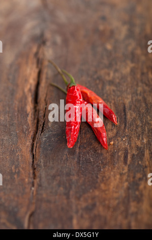 trockene rote Chilischoten über alten Holztisch Stockfoto