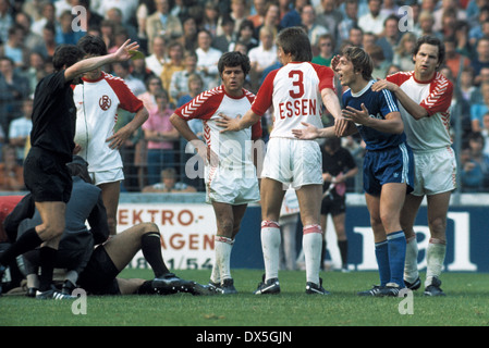 Fußball, Bundesliga, 1975/1976, Georg Melches Stadium, Rot Weiss Essen vs. FC Schalke 04 0:0, Torwart Jürgen Rynio (RWE) Verletzt bin Boden, Klaus Fischer (S04) 2.v.r. Beteuert Seine Unschuld, Essener Spieler Hans Doerre (Mitte), Gerd Wieczorkowski (N Stockfoto