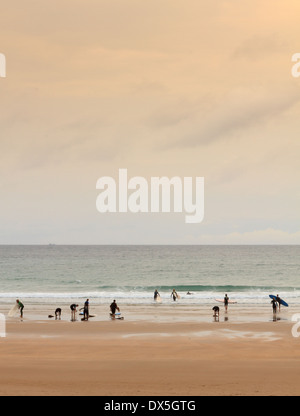 Gruppe von Surfern in Motion blur zu Fuß am Strand bei Sonnenuntergang Stockfoto