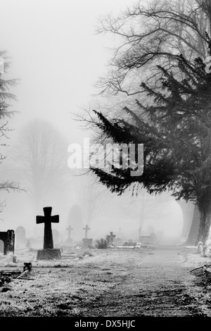 Kreuz Grabstein in den Nebel im Friedhof von Banbury, Oxfordshire, England. Monochrom Stockfoto