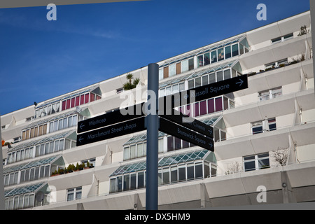 Brunswick Centre Wohnungen in Bloomsbury angesehen vom Boden mit blauen Himmel Hintergrund und Zeichen Post nach Renoir Kino & Russell Sq Stockfoto