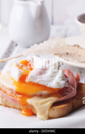 Nahaufnahme von Toast mit heißen Käse, Schinken und Spiegelei über weisse Holztisch Stockfoto