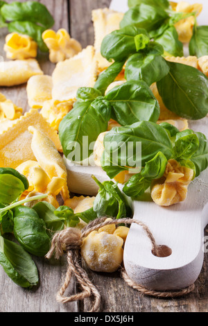 Hausgemachte Pasta Ravioli und Perle auf alten Holztisch mit frischem Basilikum. Stockfoto