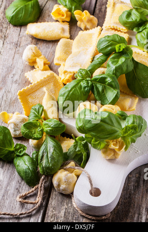 Hausgemachte Pasta Ravioli und Perle auf alten Holztisch mit frischem Basilikum Stockfoto