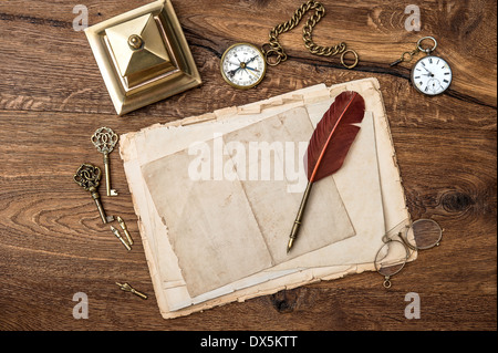 Antik-Zubehör und Büromaterial auf Holztisch. Vintage Schlüssel, Uhr, Brille, Feder Stift, Kompass. Stockfoto