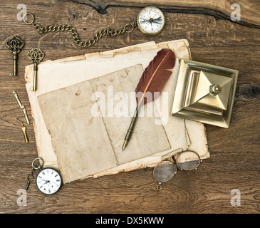 Antike Bürotechnik und Zubehör auf Holztisch. Vintage Schlüssel, Uhr, Brille, Feder Stift, Kompass. Stockfoto