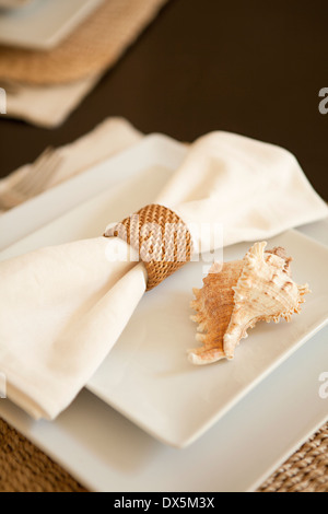 Seashell Serviette mit Serviettenring auf Ort, Einstellung, erhöhte Ansicht, Nahaufnahme, hoher Winkel Stockfoto