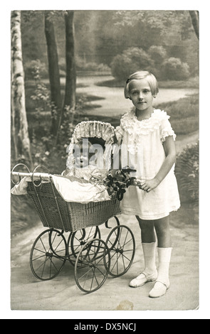 BERLIN, Deutschland - um 1930: altes Foto von kleinen Mädchen mit Puppe Spielzeug. nostalgische Vintage Bild ab ca. 1930 in Berlin
