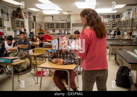 Ein San Clemente, CA, Highschool-Chemielehrer ohnmächtig Quiz zu ihrem multiethnischen Klasse. Beachten Sie lila Haare färben. Stockfoto