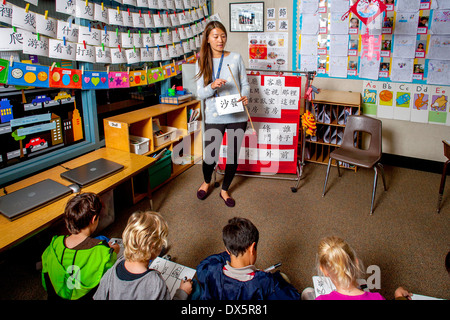 Ein asiatisch-amerikanische Lehrer führt eine erste Klasse Mandarin Chinesisch Klasse in Laguna Niguel, CA. beachten Sie chinesische Schriftzeichen und Drachen Marionette. Stockfoto