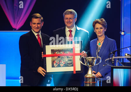 Mit einem Geschenk präsentieren Toronto, CAN., 18. März 2014 - Brenda Andress (R) und Brad Morris (L), CWHL Vorsitzender, Stephen Harper, nachdem er die kanadische Frauen Hockey League Awards Gala gerichtet. Der Ministerpräsident trat andere Würdenträger in Markham, Ontario Fahrer Bemerkungen bei Canadian Women es Hockey League Awards Gala. Bildnachweis: Victor Biro/Alamy Live-Nachrichten Stockfoto