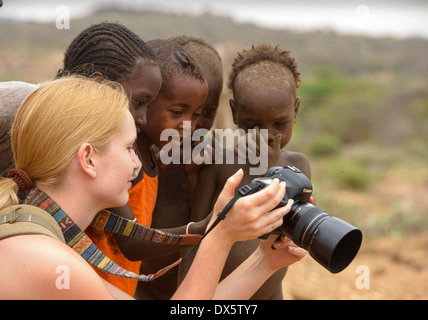 Hamer Kinder und Touristen genießen ein Foto in der Nähe von Turmi im Omo-Tal, Äthiopien Stockfoto