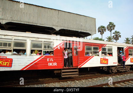 Menschen hängen von offenen Türen von s-Bahn Bahnhof Mount Lavinia in Colombo auf der Durchreise Stockfoto