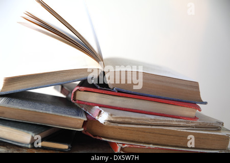 stapelt der alten Bücher neben einem Fenster Stockfoto