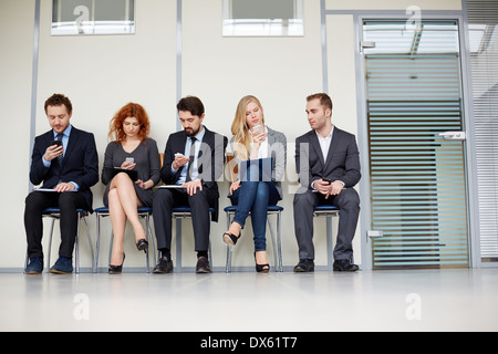 Gruppe von Geschäftsleuten mit ihren Smartphones beschäftigt Stockfoto