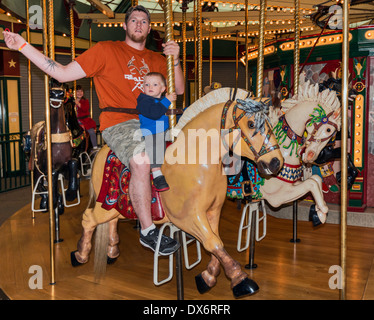 Eltern und seinem kleinen Sohn auf Karussell Pferd am Karussell für Missoula Vergnügungspark in Missoula, Montana, USA Stockfoto