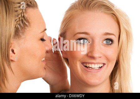 Mädchen chatten - Frau auf Freunde Ohr flüstert Stockfoto