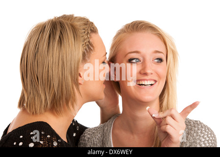 Mädchen chatten - Frau auf Freunde Ohr flüstert Stockfoto
