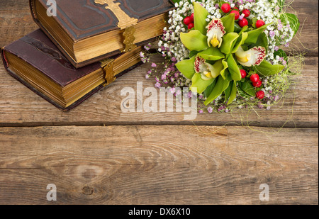 schöner Blumenstrauß Orchidee blüht und alte Bücher über rustikalen hölzernen Hintergrund. nostalgisches sentimentale Bild Stockfoto