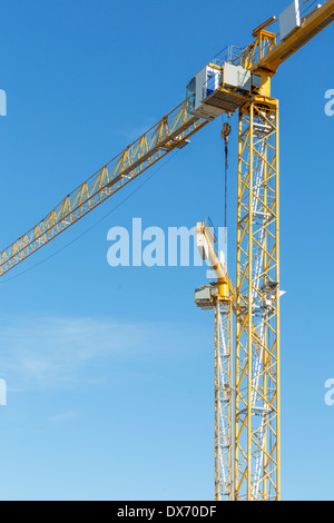 zwei gelbe Bau Krane isolierten auf blauen Himmel. Stockfoto