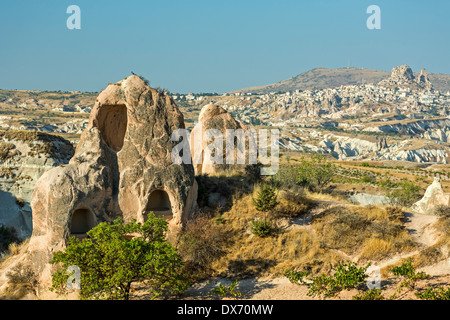 Wohnungen in Feenkamine und Uchisar (R) in der Ferne, Red Valley, Kappadokien, Türkei Stockfoto