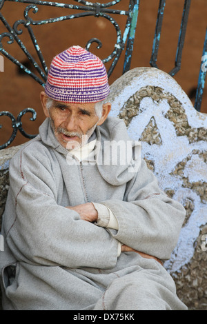 Traditionellen marokkanischen Mann tragen ein Djellaba sitzen in der Stadt Chefchaouen, Marokko Stockfoto