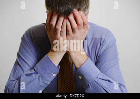 Geschäftsmann mit seinem Kopf in seine Hände. Stockfoto