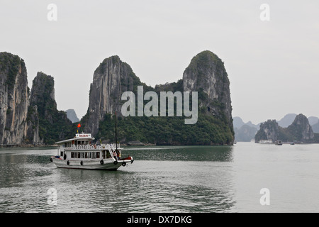 Ausflugsboot in Ha Long Bucht umgeben von Kalkstein Karst-Formationen.  Vietnam, Südostasien Stockfoto
