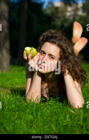 schöne junge Frau Essen Apfel im freien Stockfoto