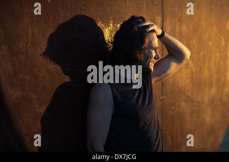 Ein junger Mann in Gedanken vor einem Training am frühen Morgen Stockfoto