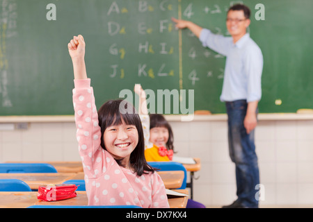 Schülerinnen und Schüler im Klassenzimmer an Lektion mit Lehrer Stockfoto