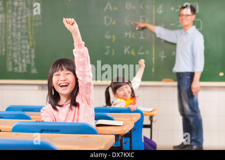 asiatische Schüler während des Unterrichts Hände erhebend Stockfoto