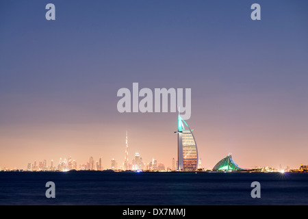 Nacht-Skyline auf Meer und luxuriöse Burj al Arab Hotel und Stadt Dubai mit Burj Khalifa tower in Ferne Vereinigte Arabische Emirate Stockfoto