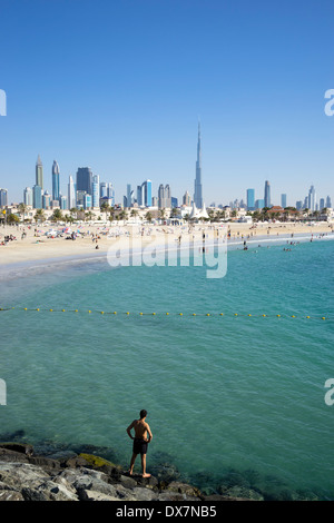 Jumeirah Open Beach mit Touristen und die Skyline der Wolkenkratzer in Dubai Vereinigte Arabische Emirate Stockfoto